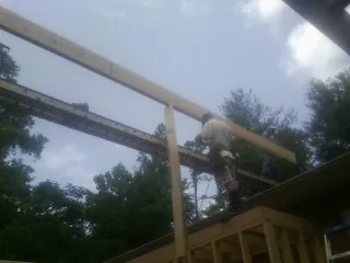 Carpenter setting a ridge beam over a new addition frame — Ice Dam Removal by Roofing Brothers in Herman