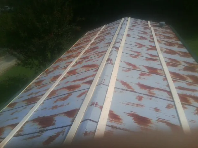 Rusted metal roof panels with new wood purlins before replacement — Storm Damage Roof Repair in Herman by Roofing Brothers
